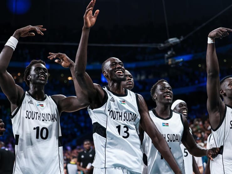 La squadra di basket del Sud Sudan esulta dopo il vittorioso debutto olimpico contro Porto Rico a Parigi 2024